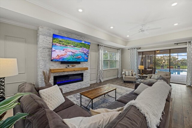 living room with a fireplace, crown molding, and hardwood / wood-style floors