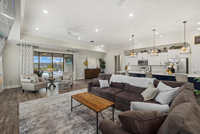 living room featuring ceiling fan, hardwood / wood-style floors, crown molding, and sink