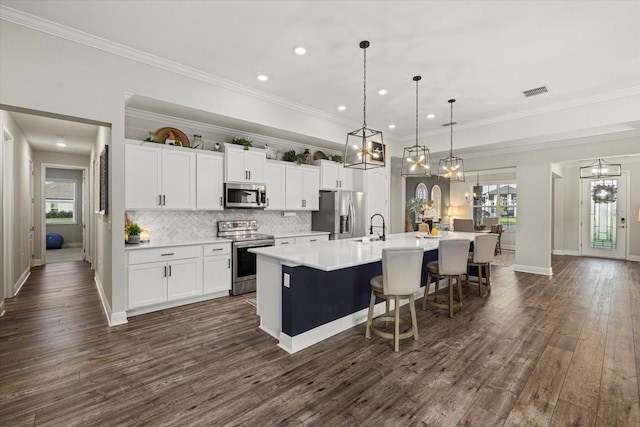 kitchen with hanging light fixtures, stainless steel appliances, plenty of natural light, and a large island