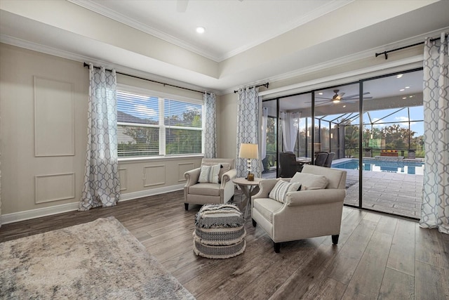 living room with dark hardwood / wood-style flooring, a healthy amount of sunlight, and ornamental molding