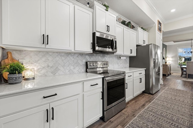 kitchen with crown molding, white cabinetry, dark hardwood / wood-style flooring, and stainless steel appliances