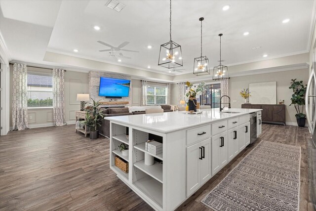 kitchen featuring a center island with sink, a healthy amount of sunlight, dark hardwood / wood-style flooring, and sink