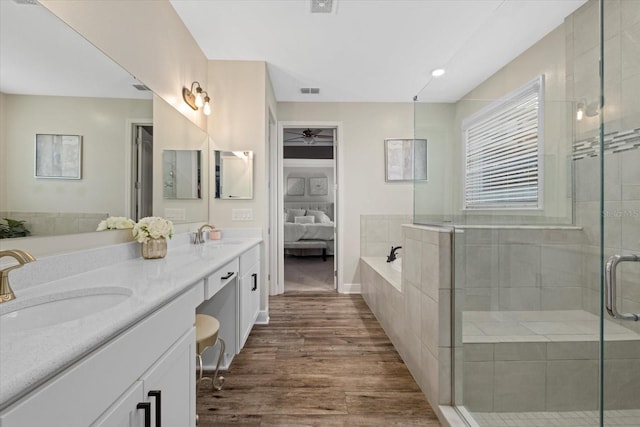 bathroom with hardwood / wood-style floors, vanity, and independent shower and bath