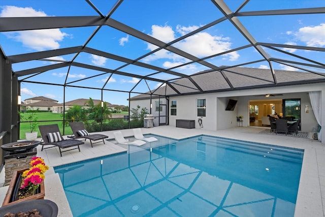 view of swimming pool with a lanai, ceiling fan, and a patio