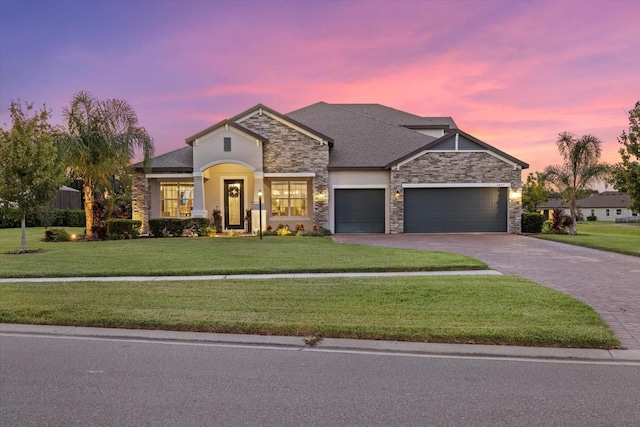 view of front of house featuring a garage and a yard