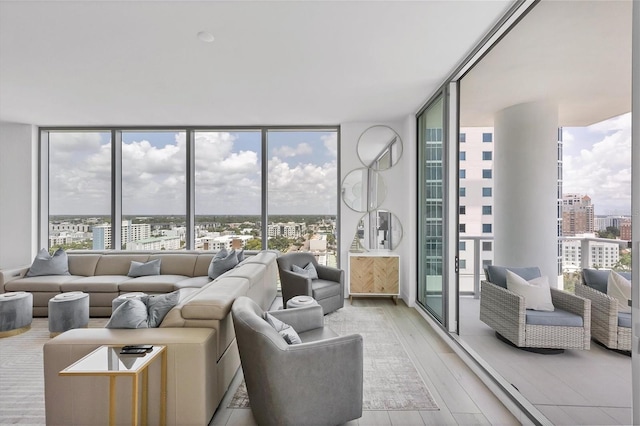 living room featuring a wealth of natural light, expansive windows, and light wood-type flooring