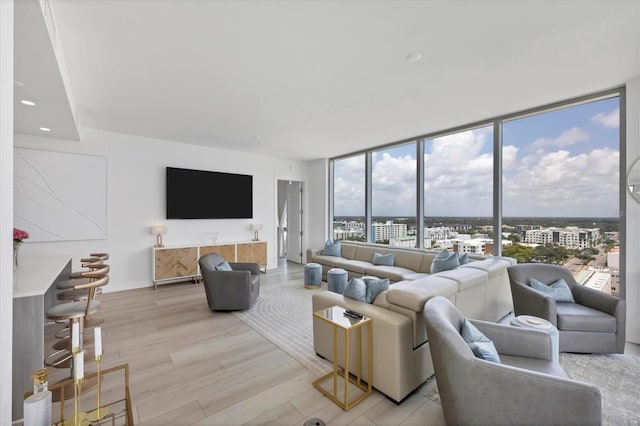 living room featuring light hardwood / wood-style flooring and a wall of windows