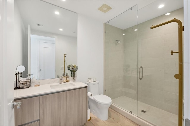 bathroom featuring vanity, toilet, and an enclosed shower