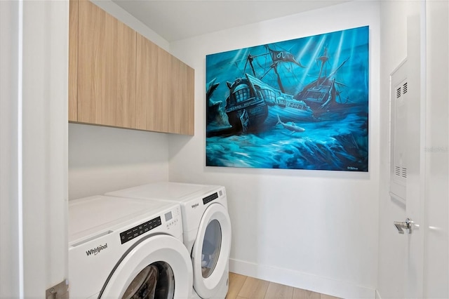 clothes washing area with cabinets, separate washer and dryer, and light hardwood / wood-style flooring