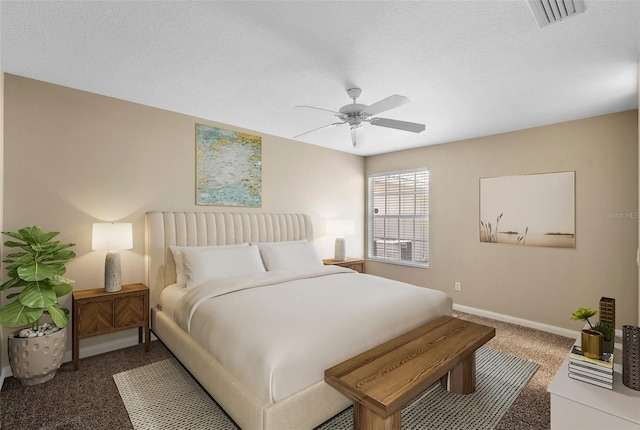 carpeted bedroom featuring ceiling fan and a textured ceiling