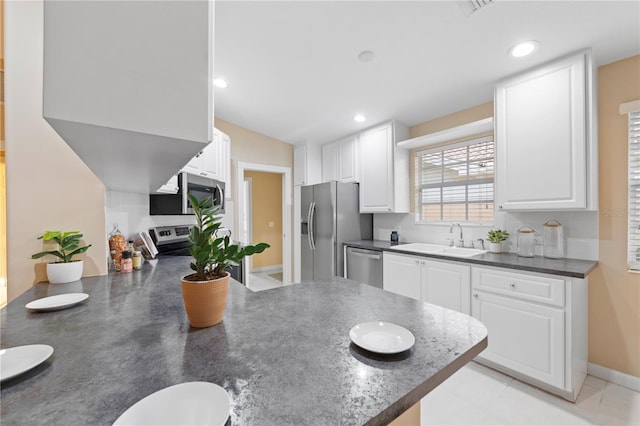 kitchen featuring white cabinets, kitchen peninsula, sink, and stainless steel appliances