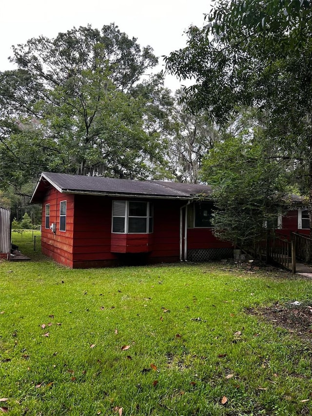 rear view of property featuring a lawn