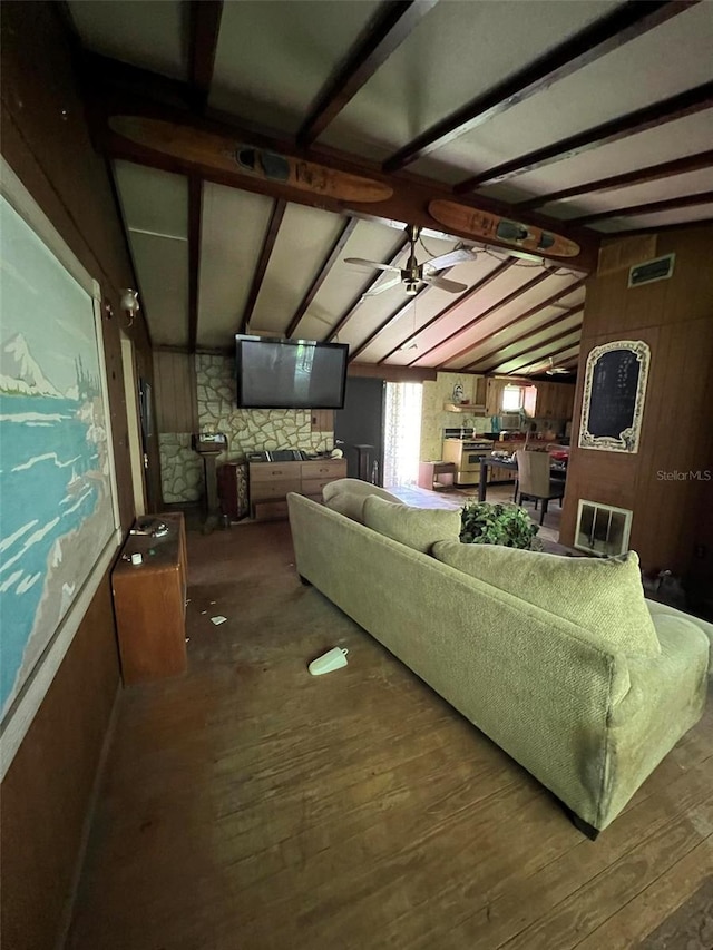 living room with wood-type flooring, lofted ceiling with beams, ceiling fan, and wood walls