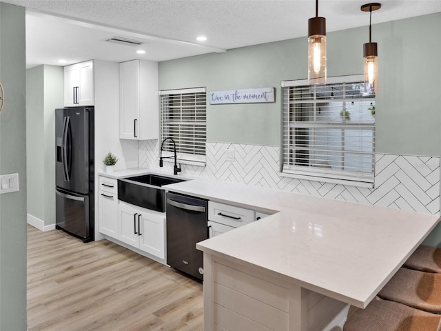 kitchen featuring backsplash, sink, dishwashing machine, light wood-type flooring, and stainless steel fridge with ice dispenser