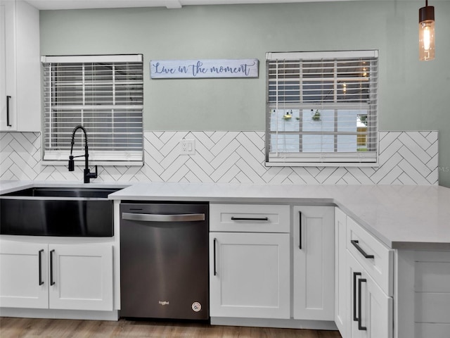 kitchen featuring dishwasher, light hardwood / wood-style floors, white cabinetry, tasteful backsplash, and sink