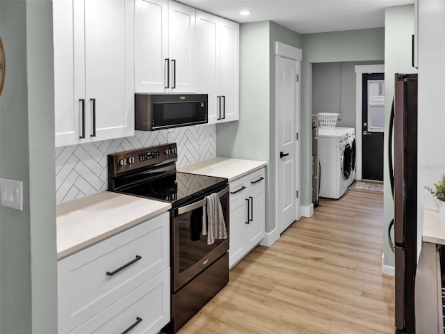 kitchen featuring decorative backsplash, washer and dryer, electric range oven, white cabinetry, and light hardwood / wood-style floors