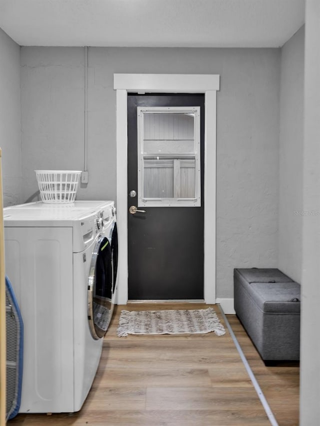 laundry room with separate washer and dryer and wood-type flooring