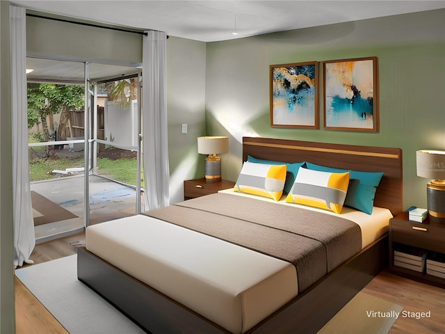 bedroom featuring access to exterior and light wood-type flooring