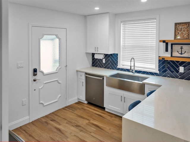 kitchen featuring light wood-type flooring, white cabinetry, backsplash, and dishwasher