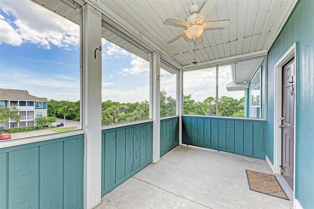 unfurnished sunroom with a ceiling fan