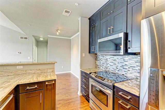 kitchen with visible vents, appliances with stainless steel finishes, backsplash, and light stone counters