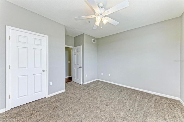 unfurnished bedroom with a ceiling fan, carpet flooring, visible vents, and baseboards