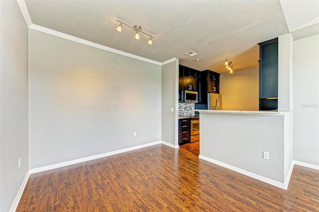 interior space with dark wood-style floors, light countertops, appliances with stainless steel finishes, and dark cabinets