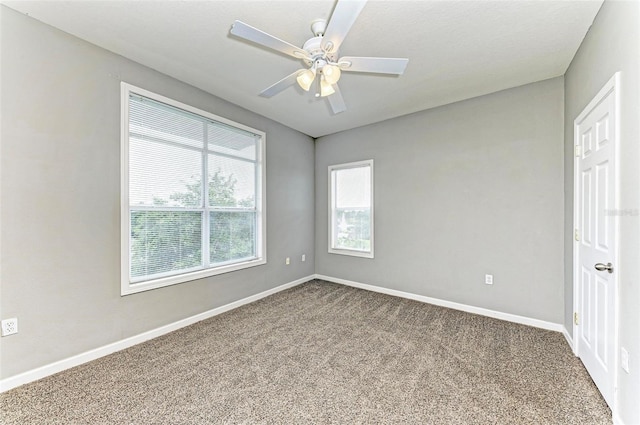 spare room with a ceiling fan, carpet flooring, and baseboards