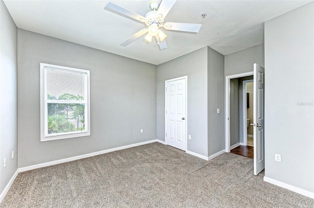 unfurnished bedroom featuring a ceiling fan, carpet, and baseboards