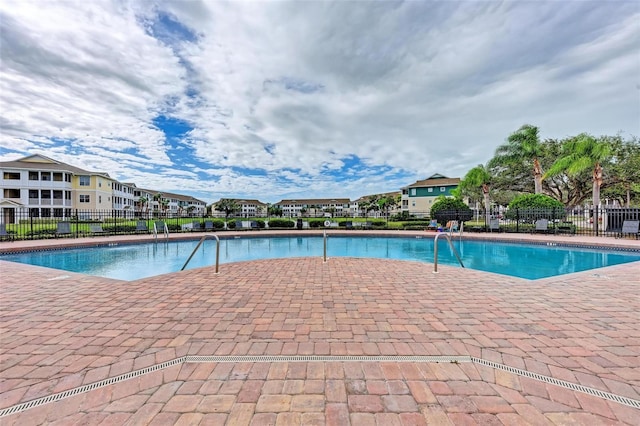 pool with fence and a residential view