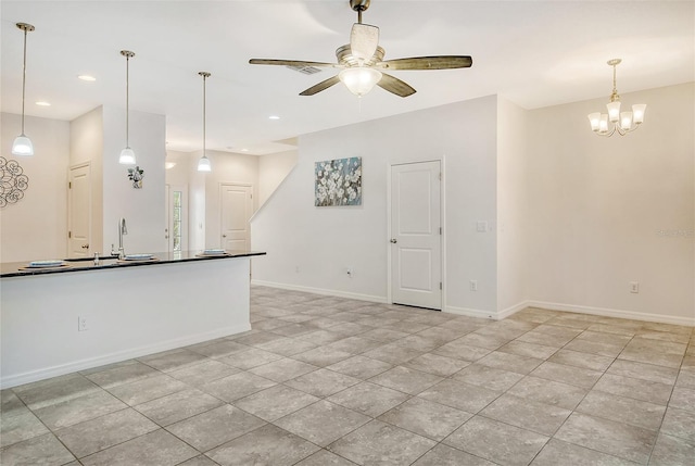 kitchen with decorative light fixtures, ceiling fan with notable chandelier, and light tile patterned floors