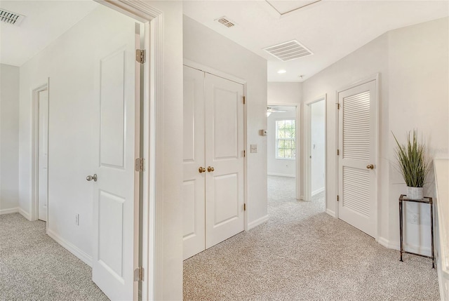 hallway featuring light colored carpet