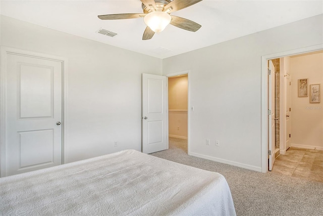 bedroom featuring ceiling fan, connected bathroom, and light carpet