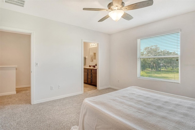 carpeted bedroom with sink, ceiling fan, and ensuite bathroom