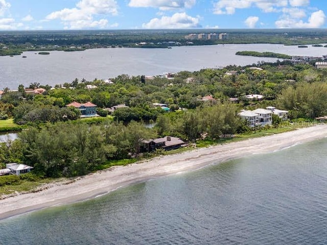 birds eye view of property with a water view and a beach view