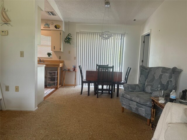 dining space featuring a textured ceiling, carpet flooring, and sink