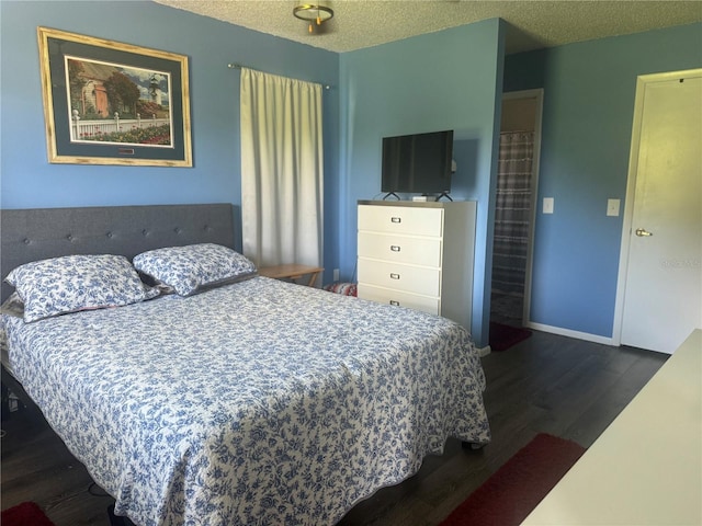 bedroom with dark wood-type flooring and a textured ceiling