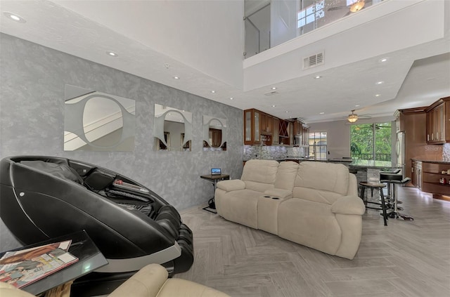 living room featuring a high ceiling, visible vents, and recessed lighting