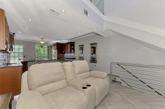 living room with visible vents, a textured ceiling, and recessed lighting