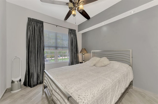 bedroom featuring ceiling fan, light wood-style floors, and baseboards