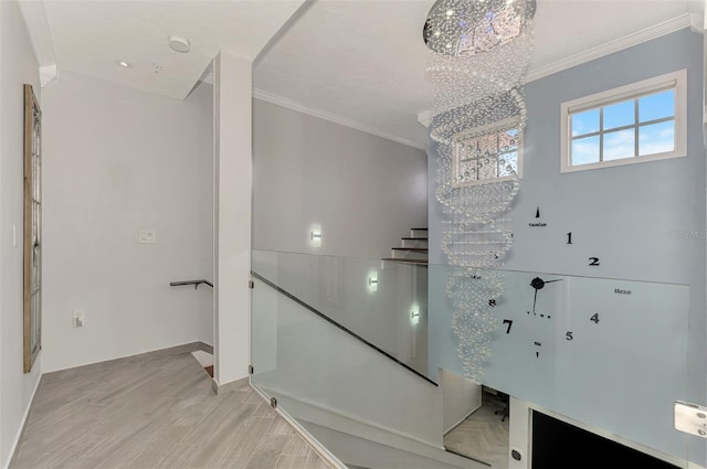 stairway featuring ornamental molding, baseboards, an inviting chandelier, and wood finished floors