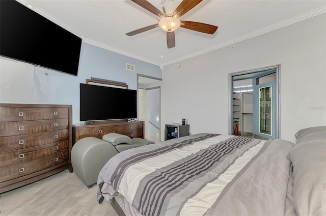 bedroom with light wood finished floors, visible vents, a ceiling fan, and ornamental molding