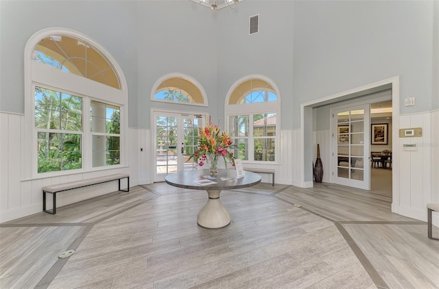 interior space featuring wainscoting, visible vents, wood finished floors, and french doors