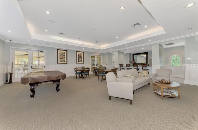 living area featuring a raised ceiling, wainscoting, visible vents, and french doors