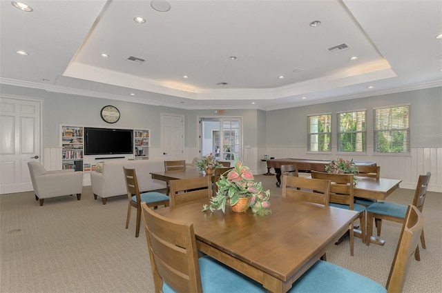 dining area featuring a wainscoted wall, light carpet, a raised ceiling, and visible vents