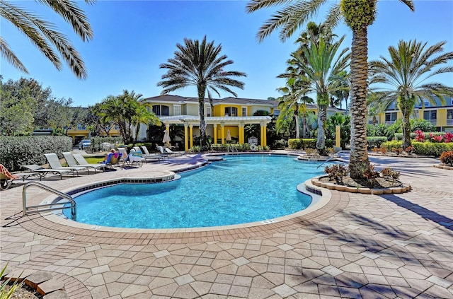 community pool with a patio area and a pergola