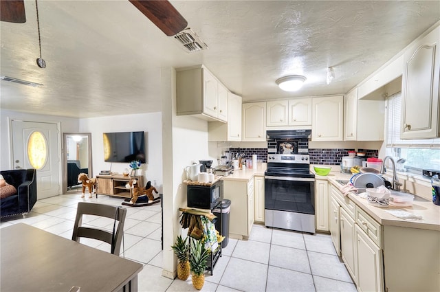 kitchen featuring sink, decorative backsplash, electric stove, and light tile patterned flooring