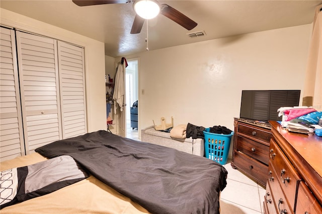 tiled bedroom featuring ceiling fan and a closet