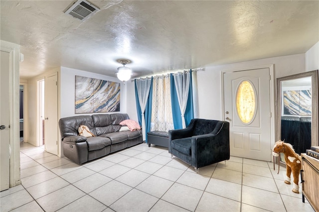 living room featuring a textured ceiling and light tile patterned floors