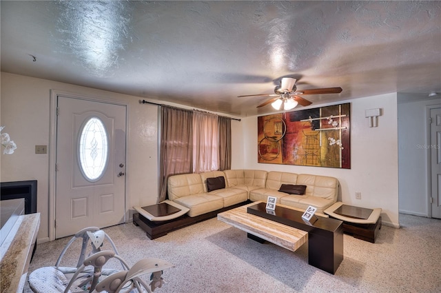 living room with ceiling fan and a textured ceiling